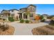 Inviting two-story home showcasing a landscaped front yard, stone accents, and a concrete walkway at 6833 Longpark Dr, Parker, CO 80138