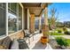 Cozy front porch with stone pillars, seating, and view of the street at 6833 Longpark Dr, Parker, CO 80138