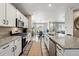 Modern kitchen with white cabinetry, stainless steel appliances, granite countertops, and an open view of the dining area at 6833 Longpark Dr, Parker, CO 80138