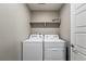 Clean laundry room featuring a washer and dryer, and a shelf at 6833 Longpark Dr, Parker, CO 80138