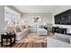 Comfortable living room featuring a large sectional sofa, modern decor, and wood flooring at 6833 Longpark Dr, Parker, CO 80138