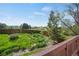 A view of the fenced backyard and lush green landscaping from the wooden deck at 9386 W Geddes Pl, Littleton, CO 80128