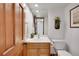 Cozy bathroom with wood-toned vanity and modern fixtures at 9386 W Geddes Pl, Littleton, CO 80128