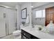 Bright bathroom with a glass-enclosed shower, modern fixtures, and a stylish vanity with black cabinetry and white countertop at 9386 W Geddes Pl, Littleton, CO 80128