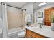 Charming bathroom with a shower-tub combo, updated fixtures, vanity with wooden cabinetry, and a skylight at 9386 W Geddes Pl, Littleton, CO 80128