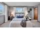 Comfortable bedroom with soft carpet, gray walls, and a large window with natural light and stylish decor at 9386 W Geddes Pl, Littleton, CO 80128