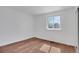 Bright bedroom with hardwood flooring, fresh white walls, and a window showcasing natural outdoor light at 9386 W Geddes Pl, Littleton, CO 80128