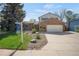 Charming two-story home with brick facade, attached garage, and well-maintained front yard at 9386 W Geddes Pl, Littleton, CO 80128