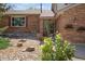 Close up of a brick home entrance with decorative plants and a well-kept garden at 9386 W Geddes Pl, Littleton, CO 80128