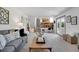 Spacious living room adjacent to the kitchen and featuring neutral tones and ample natural light at 9386 W Geddes Pl, Littleton, CO 80128
