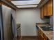 Kitchen area with stainless steel appliances, granite countertops, and wooden cabinets at 10872 W Evans Ave # 2E, Lakewood, CO 80227
