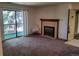 Living room featuring a fireplace, sliding glass doors to a balcony and neutral-colored carpet at 10872 W Evans Ave # 2E, Lakewood, CO 80227