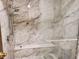 Walk-in shower featuring marble-style tile and a built-in bench at 10872 W Evans Ave # 2E, Lakewood, CO 80227