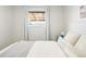 Bright bedroom with neutral decor, soft textiles, and natural light from the window at 2801 N Garfield St, Denver, CO 80205