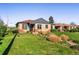 Well-kept brick house with a green lawn, mature trees, and landscaping on a clear day at 2801 N Garfield St, Denver, CO 80205