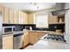 Cozy kitchen featuring stainless appliances, light wood cabinets, and black backsplash at 2801 N Garfield St, Denver, CO 80205