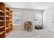 Neutral carpeted bedroom featuring a desk, trunk, and light-wood bookshelf next to the windows at 13850 Meadowbrook Dr, Broomfield, CO 80020