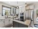 Bright kitchen boasts tile floors, stainless steel appliances, and central island with cooktop at 13850 Meadowbrook Dr, Broomfield, CO 80020