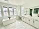 Luxury bathroom with a freestanding tub, marble tile, and double vanities showcasing high-end finishes and abundant natural light at 16521 Black Rose Cir, Parker, CO 80134