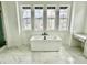 Beautiful bathroom with large windows, freestanding tub, dual vanity, and marble floors offers a serene and luxurious experience at 16521 Black Rose Cir, Parker, CO 80134