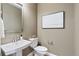 A half-bath features modern fixtures, a pedestal sink, and neutral decor providing a clean, simple design at 9354 Quartz St, Arvada, CO 80007