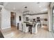 Bright open dining area with modern chandelier and seamless flow into the kitchen with white cabinets at 9354 Quartz St, Arvada, CO 80007