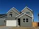 Charming two-story home featuring gray wood siding, white trim, and a two-car garage under a clear blue sky at 9354 Quartz St, Arvada, CO 80007