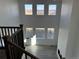 Bright great room with tall windows, wood floors, fireplace, and dark brown stair railing at 9354 Quartz St, Arvada, CO 80007