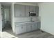 Stylish kitchenette with gray cabinets, subway tile backsplash, stainless steel sink, and modern appliances at 9354 Quartz St, Arvada, CO 80007