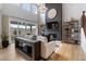 Bright living room featuring high ceilings, large windows, fireplace, and a modern chandelier at 9354 Quartz St, Arvada, CO 80007
