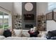 Bright living room featuring high ceilings, fireplace, decorative shelving, and wood floors at 9354 Quartz St, Arvada, CO 80007