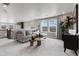 Open-concept living room with a gray sectional couch and natural light at 9354 Quartz St, Arvada, CO 80007