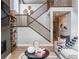 Bright living room featuring high ceilings, staircase, fireplace, and decorative shelving at 9354 Quartz St, Arvada, CO 80007