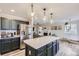 Open-concept kitchen with stainless steel appliances, island seating, and seamless flow to the living room at 19827 E Prentice Ave, Centennial, CO 80015