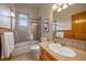 Well-lit bathroom featuring a shower over tub, tile surround, and vanity with ample counter space at 31028 Big Bear Dr, Evergreen, CO 80439