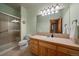 Bright bathroom features a vanity with a large mirror, a shower, and a toilet at 31028 Big Bear Dr, Evergreen, CO 80439