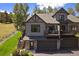 Charming home features an upper deck, a two-car garage, and wooden staircase at 31028 Big Bear Dr, Evergreen, CO 80439