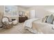 Bright bedroom featuring a comfortable chair, dresser with double mirrors, and a cozy bed, perfect for relaxation at 6279 Oxford Peak Pl, Castle Rock, CO 80108