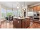 Stylish kitchen with granite island, wood floors, stainless steel appliances, and a breakfast nook with abundant natural light at 6279 Oxford Peak Pl, Castle Rock, CO 80108
