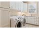 Well-lit laundry room with modern appliances, white cabinetry, counter space, and a window at 6279 Oxford Peak Pl, Castle Rock, CO 80108