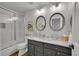 Bathroom featuring double sinks, granite counters, modern lighting, and a glass-enclosed shower at 215 Mcafee Cir, Erie, CO 80516