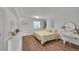 Bright bedroom featuring wood floors, white walls, and a dedicated desk area at 215 Mcafee Cir, Erie, CO 80516