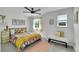 Bright bedroom features a colorful bed, white walls, two windows and a soft white bench at 215 Mcafee Cir, Erie, CO 80516