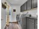 Laundry room featuring modern washer and dryer set and grey cabinets at 215 Mcafee Cir, Erie, CO 80516