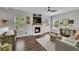 Inviting living room featuring wood floors, a fireplace, large windows, and comfortable seating at 215 Mcafee Cir, Erie, CO 80516