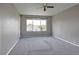 Bright bedroom featuring gray walls, plush carpet, and a large window at 245 Homestead Way, Brighton, CO 80601