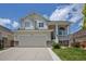 Inviting two-story home with a two-car garage, charming porch, stone accents, and a well-maintained lawn at 245 Homestead Way, Brighton, CO 80601