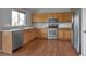 Well-lit kitchen with stainless steel appliances, granite countertops, wood cabinets, and a large window at 245 Homestead Way, Brighton, CO 80601