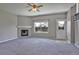 Cozy living room with gray carpet, fireplace, ceiling fan and natural light at 245 Homestead Way, Brighton, CO 80601