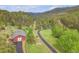Aerial view of the property's barn nestled in a lush, green, mountainous landscape at 24 Pine Valley Rd, Evergreen, CO 80439